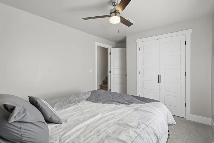 Neutral gray wall paint, white trim, and a ceiling fan with light fixture