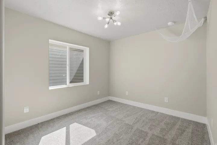 Carpeted flooring, neutral wall tones, white trim, recessed window, and a contemporary ceiling light fixture