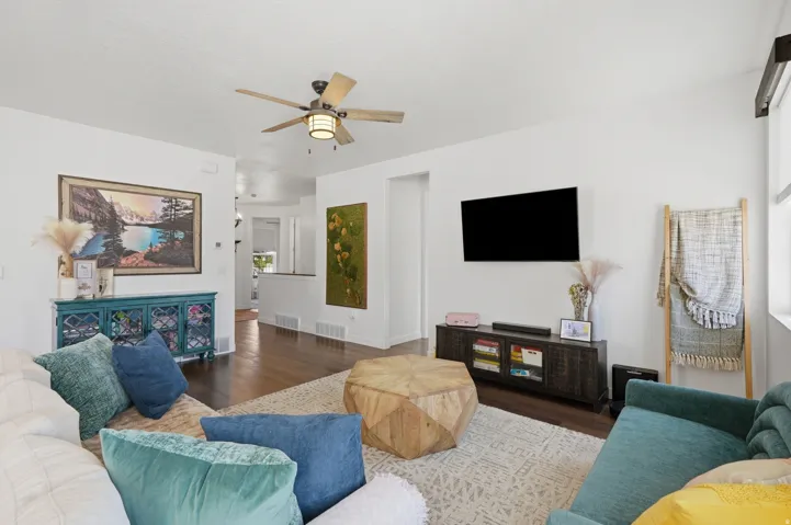 Hardwood flooring, white walls, recessed lighting, ceiling fan with integrated light, built-in display console