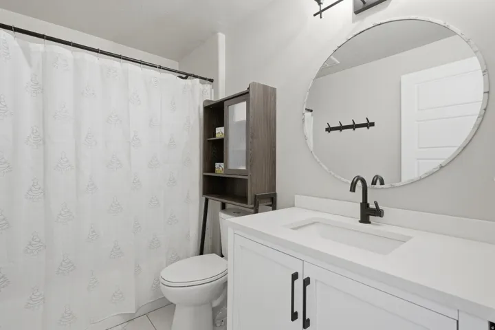 White vanity with black hardware, rectangular undermount sink, and matte black faucet