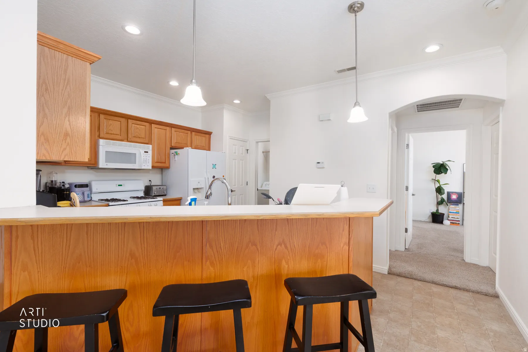 Kitchen featuring wood-finish cabinetry, a breakfast bar, recessed lighting, and pendant lights