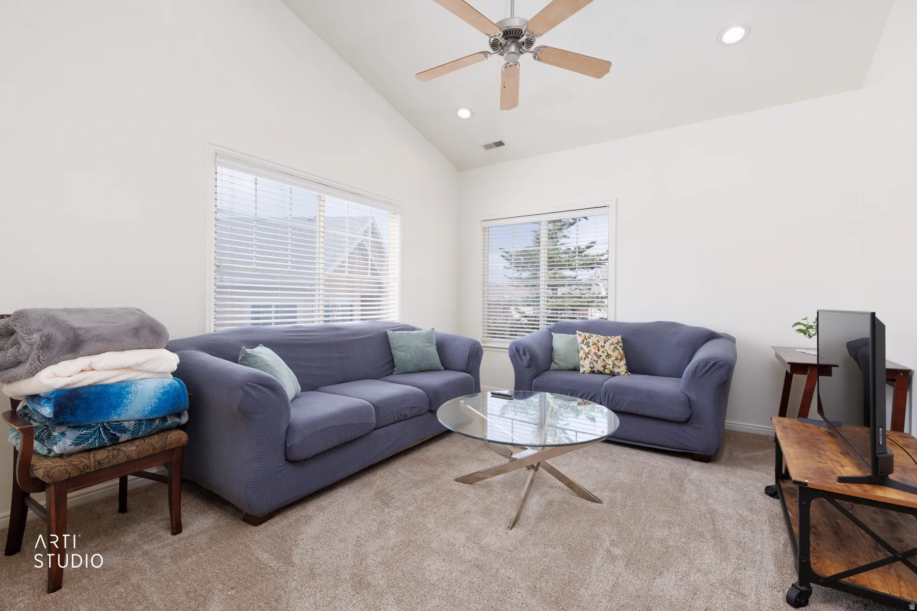Vaulted ceiling with a ceiling fan, recessed lighting, expansive windows, and light-toned carpet flooring