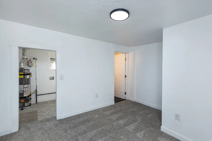 Plush carpeting, recessed ceiling lighting, a water heater, and a white paneled door
