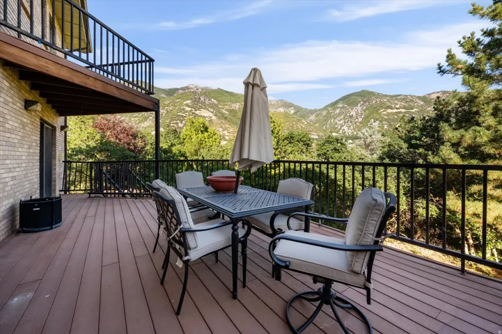 Expansive outdoor deck with mountain scenery, featuring composite decking and a wrought iron railing