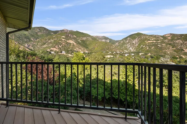 Balcony with composite decking, black metal railing, and a mountainous backdrop