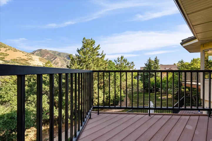 Expansive outdoor private  deck with composite decking and black metal railings off of owner's bedroom suite.