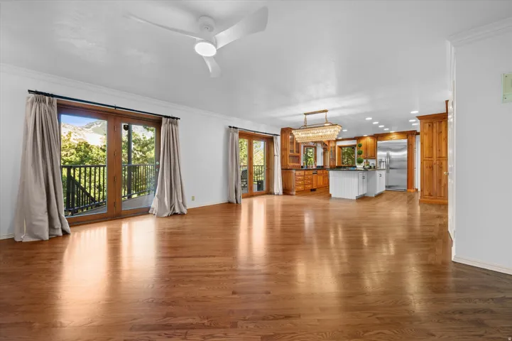 Hardwood flooring throughout, with ceiling fan, recessed lighting, and kitchen featuring stainless steel appliances, central island, and wood cabinetry
