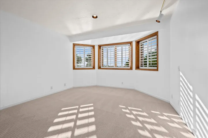 Bay window featuring wood-frame windows and white plantation shutters