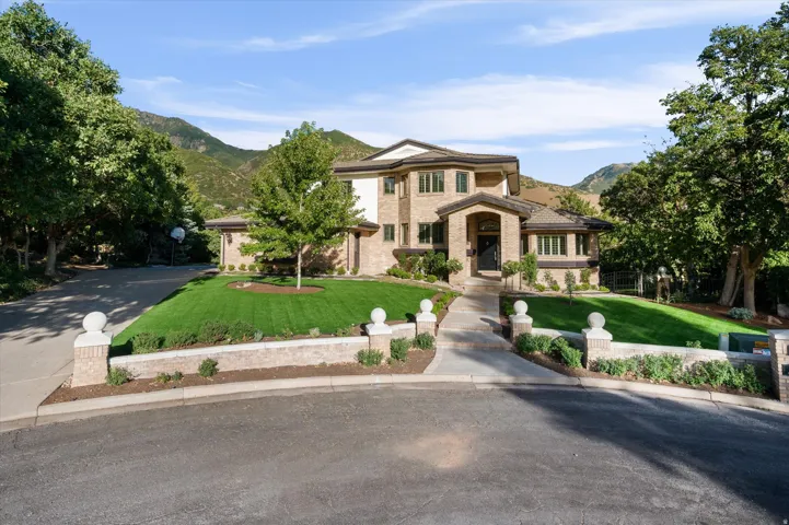 Brick and stucco exterior with multiple windows, an arched entry, and a covered porch