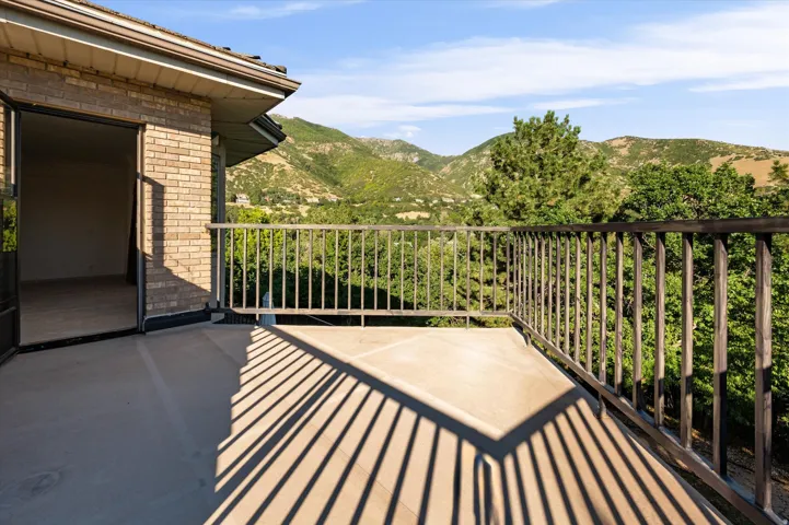 Brick exterior featuring a private balcony with metal railing, offering expansive scenery