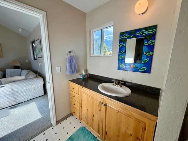 Wood-finish vanity with an integrated sink and dark countertop