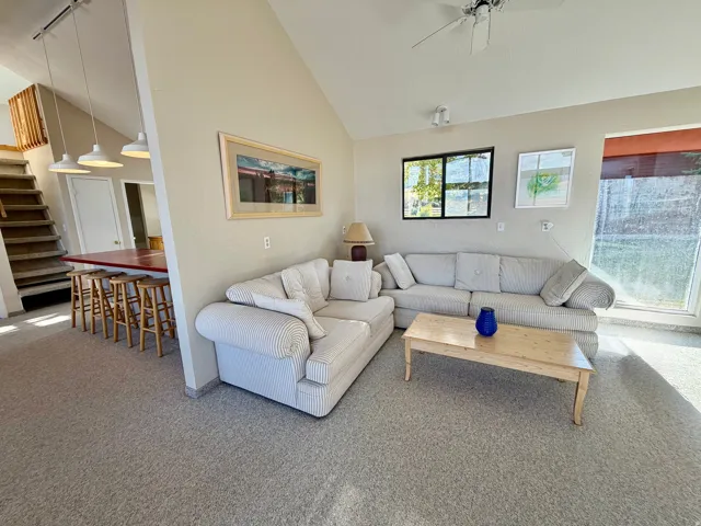Vaulted ceiling with ceiling fan, recessed lighting, and a partially visible staircase
