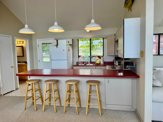 Kitchen featuring a red countertop, white cabinetry, a built-in sink, and pendant lighting