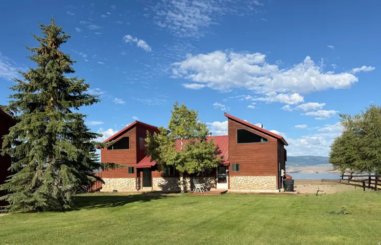 Wood-sided exterior with a red metal roof and stone foundation
