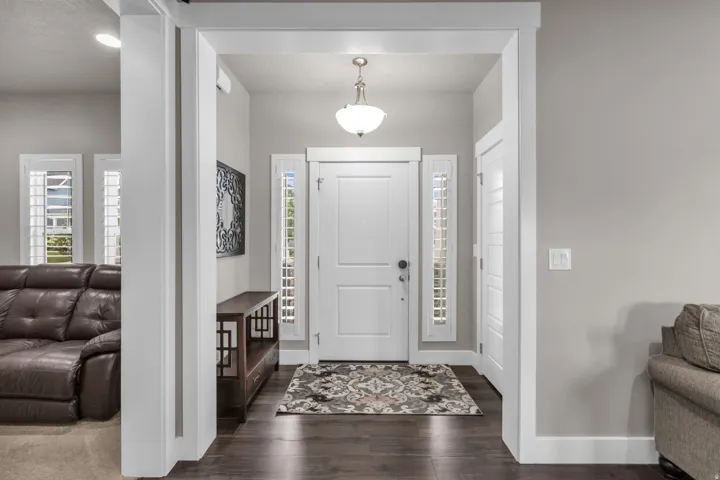 Entryway featuring a paneled door, vertical window panels, wood-finish flooring, and a semi-flush mount light fixture