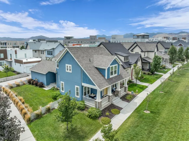 Two-story residence with blue siding and shake accents, featuring a covered front porch with white columns and stone bases