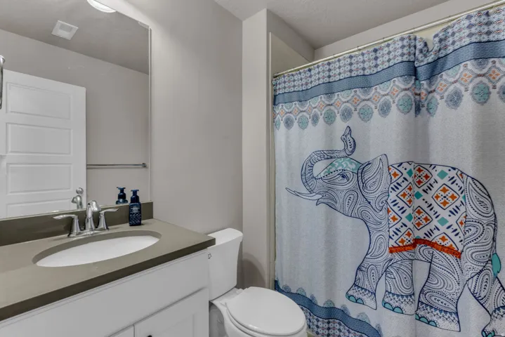 Neutral wall paint and a single-basin vanity with a solid surface countertop, chrome faucet, and integrated sink