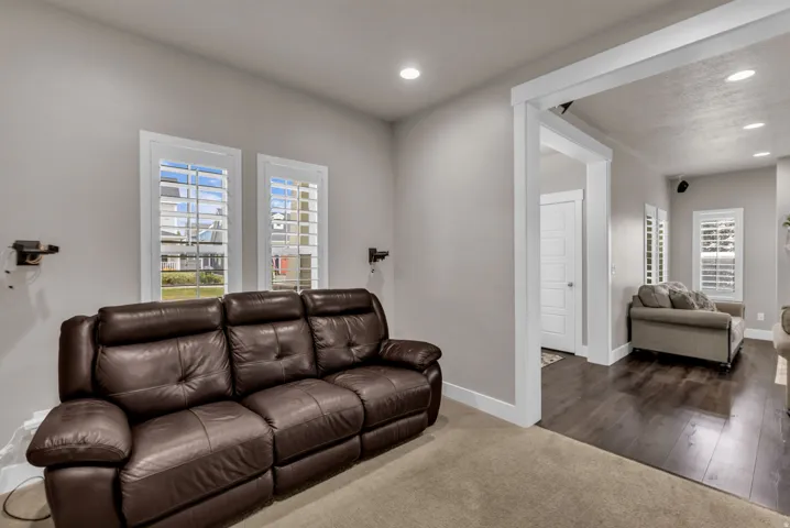 Recessed lighting, white trim accents, and broad windows with louvered shutters