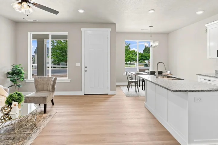 Light wood-finish flooring throughout, recessed lighting, and a ceiling fan with light fixture