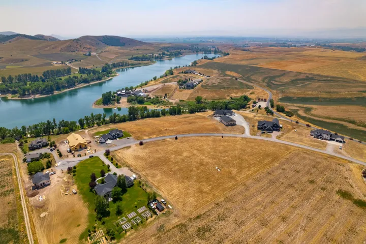 Expansive property featuring a large body of water, rolling hills, and multiple residential structures