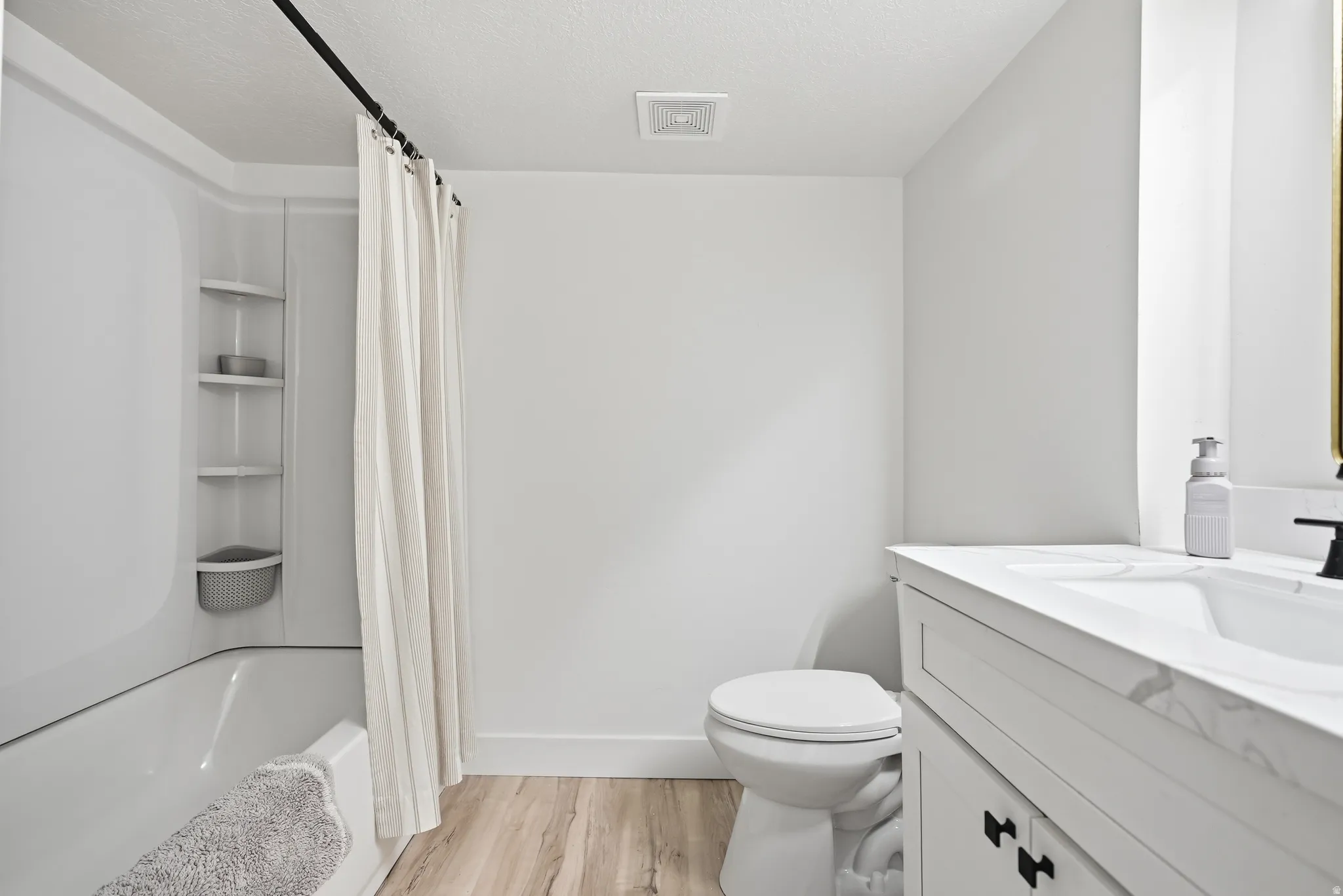 White vanity with a single basin sink, matte black faucet, and white countertop