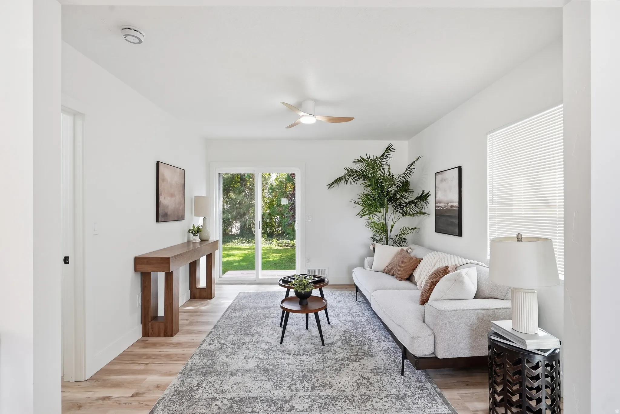 Recessed lighting, wood-finish flooring, ceiling fan, sliding glass door, and white walls