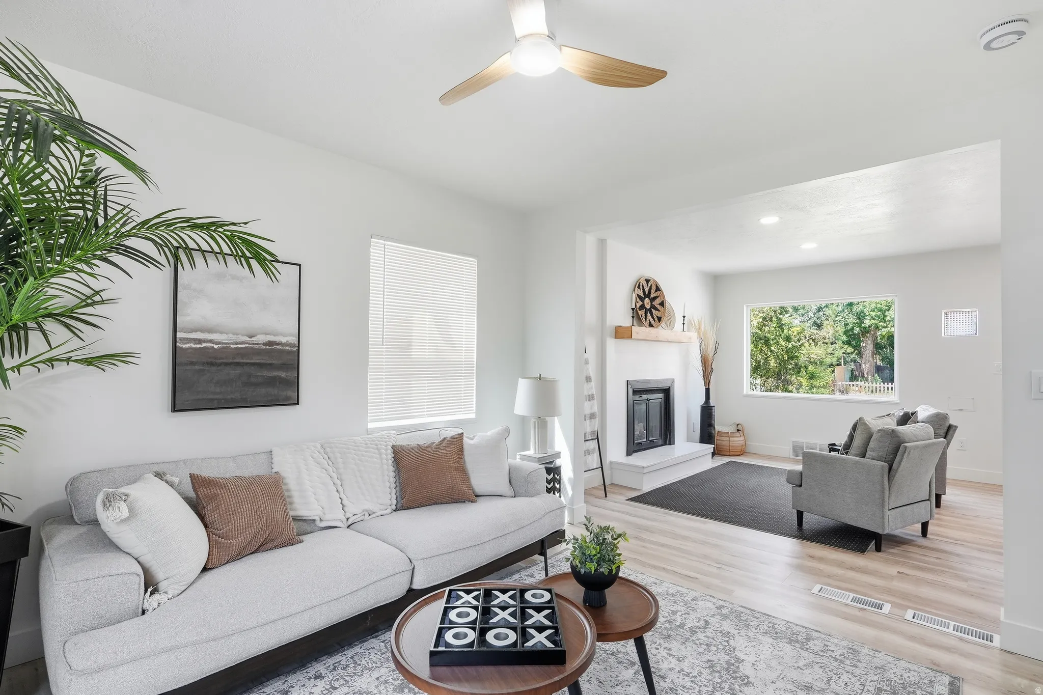 Recessed lighting, wood-finish flooring, white walls, and a ceiling fan