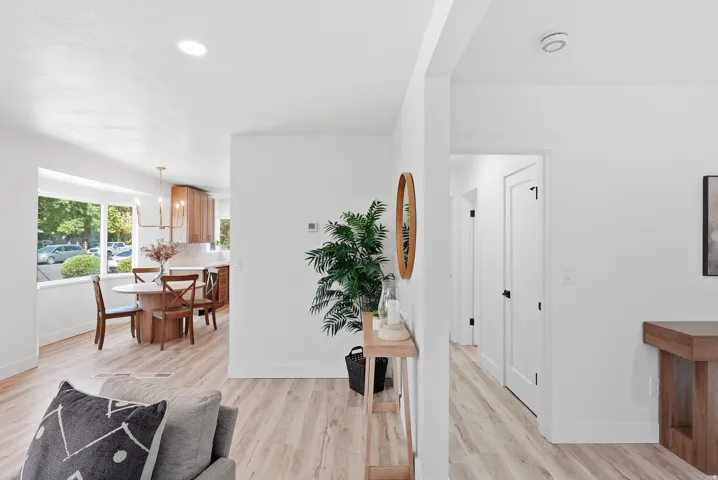 Recessed ceiling lighting, light wood-finish flooring, white painted walls, white interior doors with black hardware, and bay windows