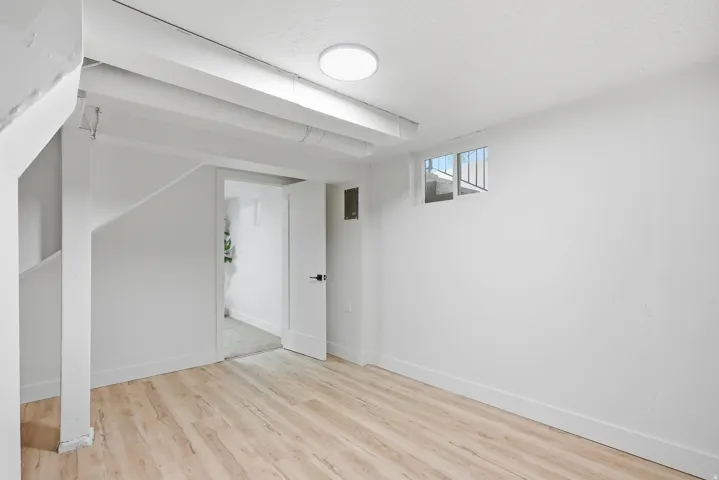 Wood-finish flooring, white walls, white trim, and a flush-mount ceiling light