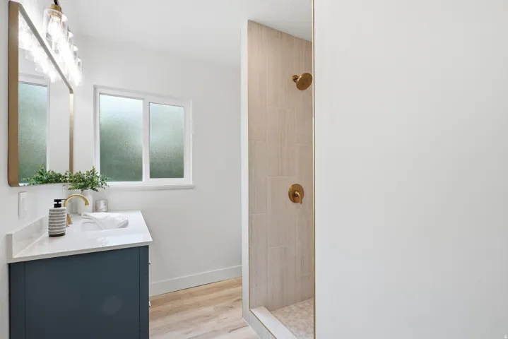 Vanity with a quartz countertop, integrated sink, and gold-finish faucet