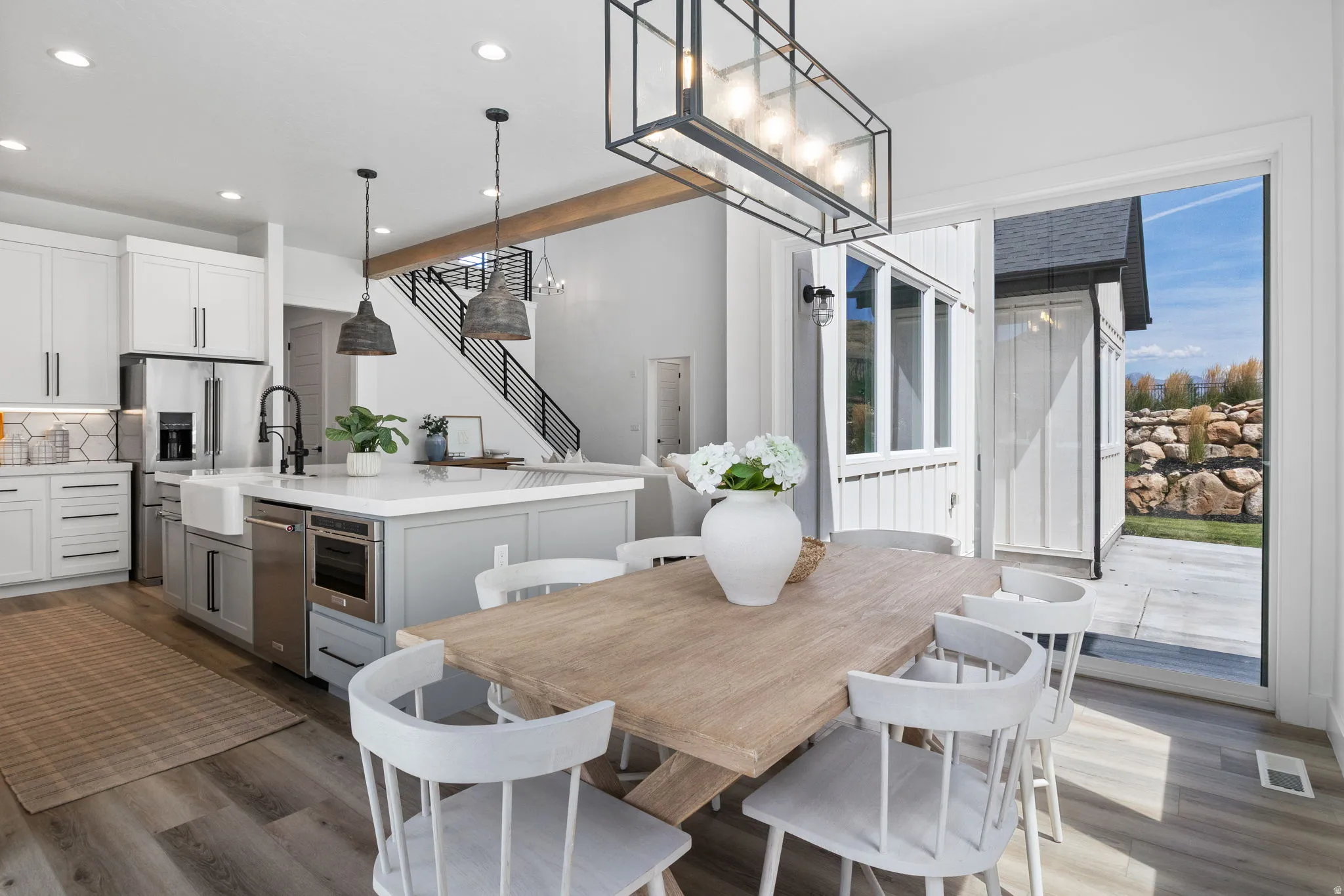 Gourmet kitchen with white cabinetry, large island with integrated sink, and stainless steel appliances