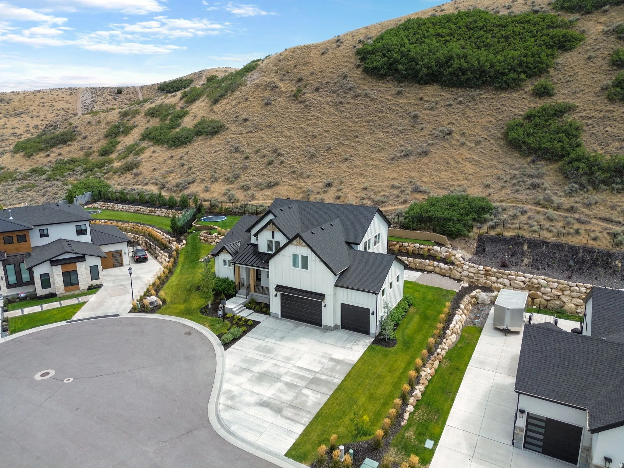 Contemporary-style home featuring a dark shingle roof, white vertical siding, and a two-car garage