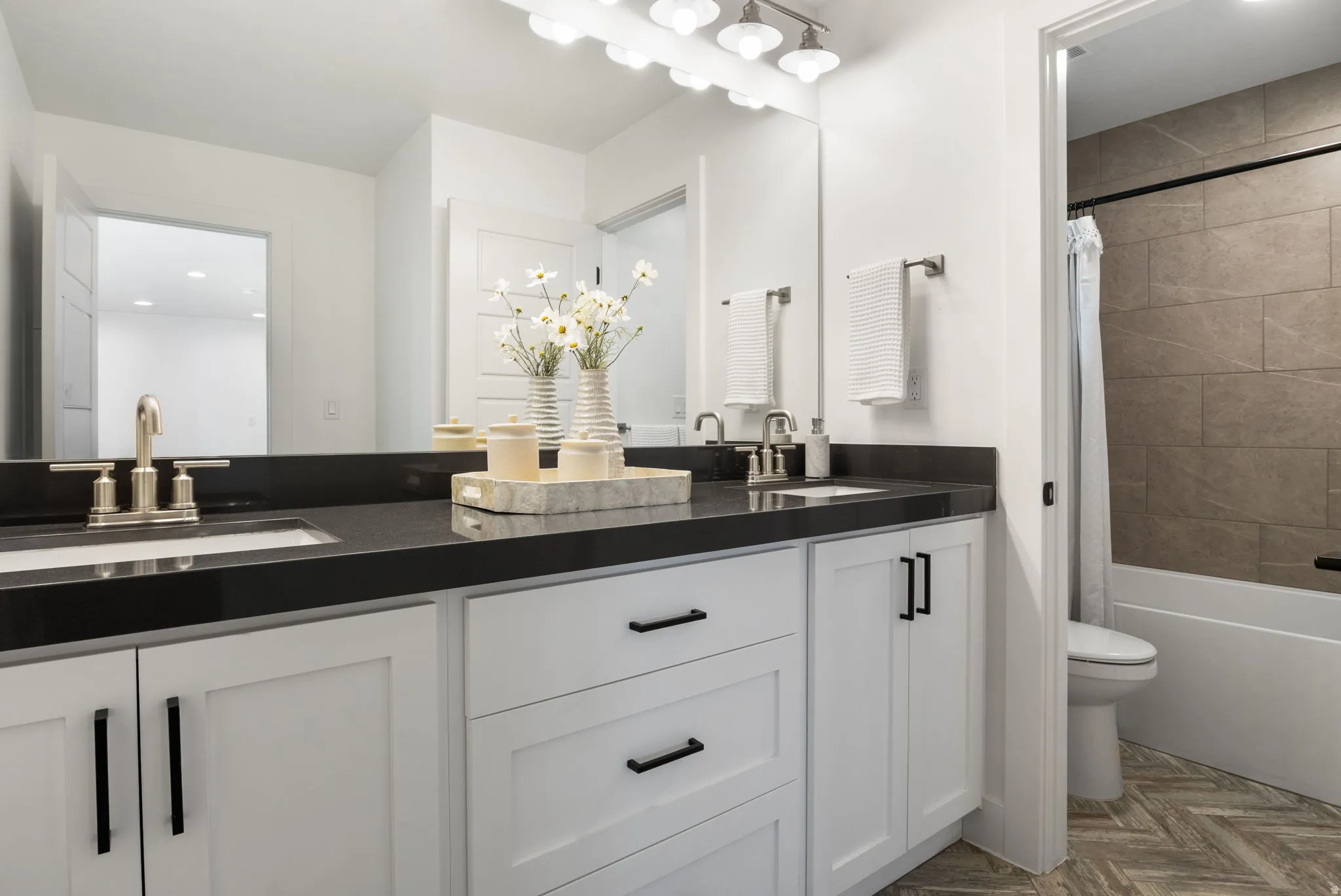 Dual vanity with a dark countertop and integrated sinks