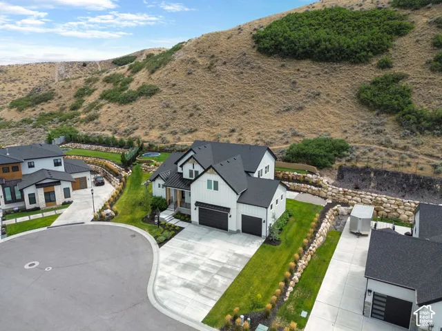 Contemporary-style home featuring a dark shingle roof, white vertical siding, and a two-car garage