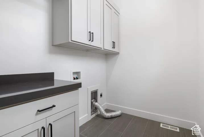 Built-in cabinetry with dark hardware, dark countertop, and tiled flooring