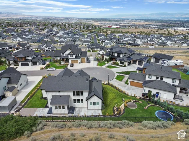 Modern residential architecture with dark roofing, a cul-de-sac street design, and landscaped yards