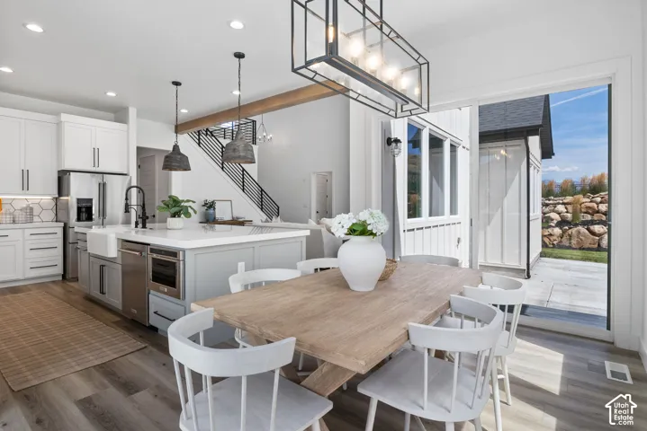 Gourmet kitchen with white cabinetry, large island with integrated sink, and stainless steel appliances