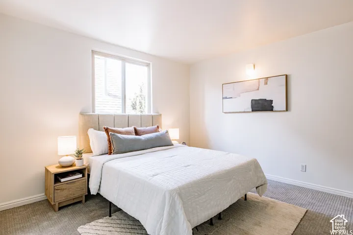 Carpeted flooring, white walls, and a window providing natural light