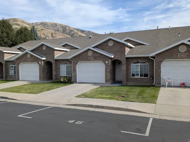 Brick exterior townhomes featuring arched entryways and attached garages