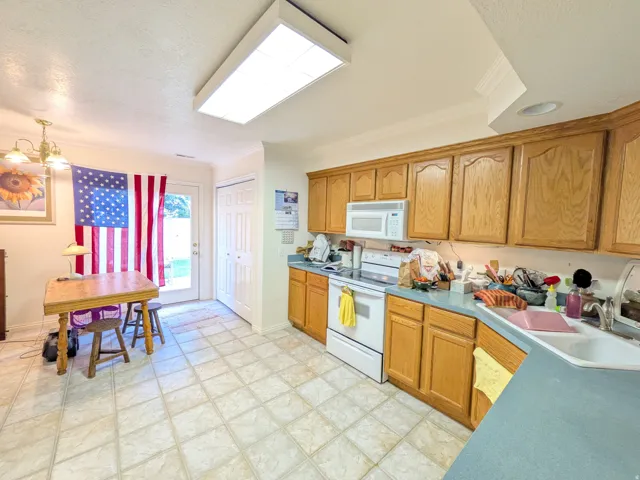 Kitchen featuring light wood cabinetry and light-toned tile flooring