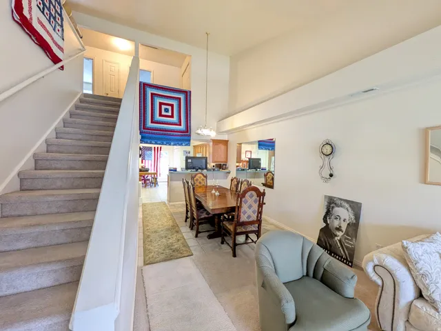 Carpeted staircase with white handrail, leading to an upper level