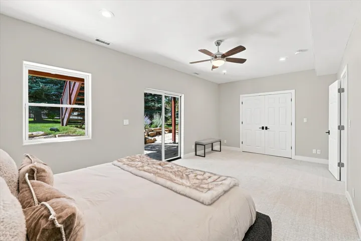 Recessed lighting, ceiling fan with light fixture, carpeted flooring, sliding glass door, and double-door closet