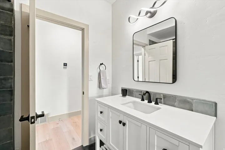 White vanity with a rectangular undermount sink and matte black faucet