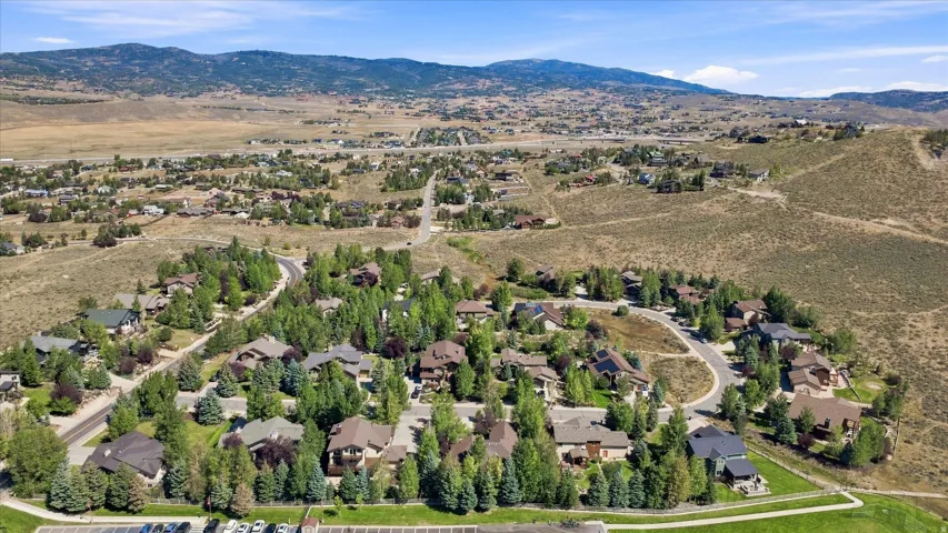 Expansive community with mature trees, paved roads, and distant mountains