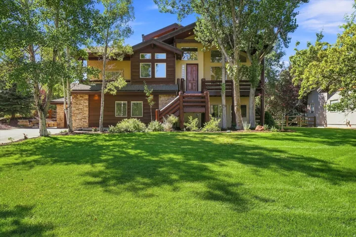 Expansive front lawn with mature trees