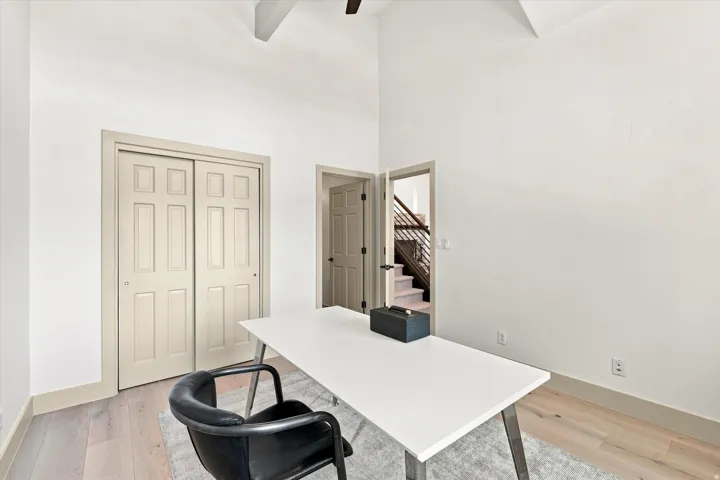 Vaulted ceiling with a ceiling fan, wood-finish flooring, and panel doors