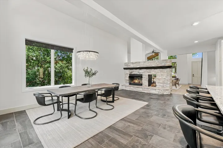 Spacious dining area with a stone-clad fireplace and hearth