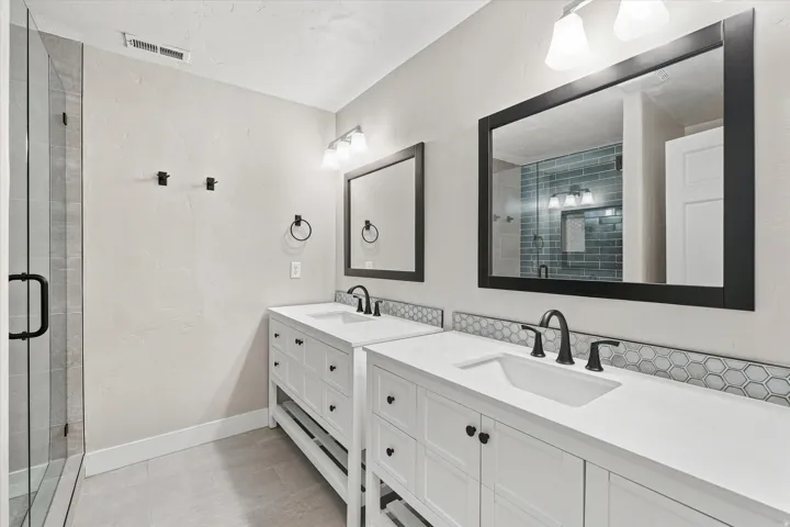 Dual vanities with integrated sinks, framed mirrors, and matte black fixtures