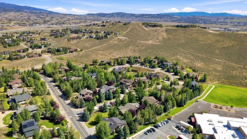 Residential neighborhood featuring mature trees, paved roads, and distant mountain topography