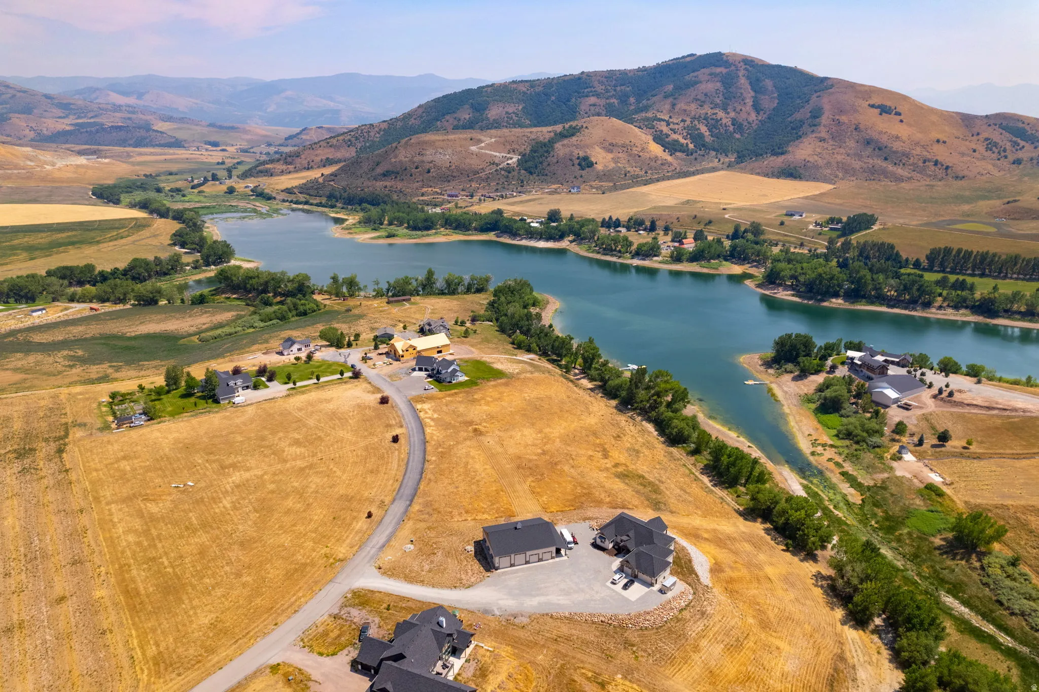 Expansive properties with partial water frontage on a tranquil lake, surrounded by undulating hills and natural terrain